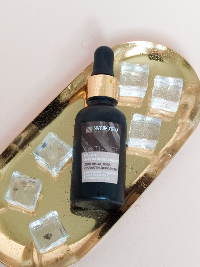services-03 Close-up of a revitalizing serum bottle on a gold tray with ice cubes, conveying luxury skincare.